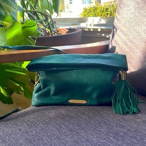 Green leather cross body bag with gold accents and tassel